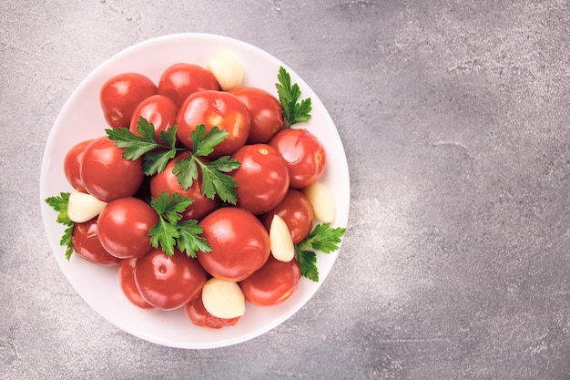 Image of red pizzcled canned tomatoes on a plate Image of red canned tomatoes on a white plate