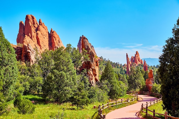 Image of red spike pillars of rock in park with paved winding\
trail