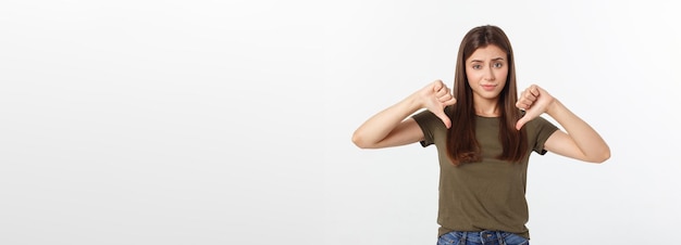 Image of resentful woman with long dark hair showing thumbs down isolated over gray background