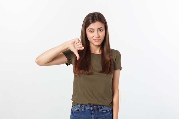 Image of resentful woman with long dark hair showing thumbs down isolated over gray.