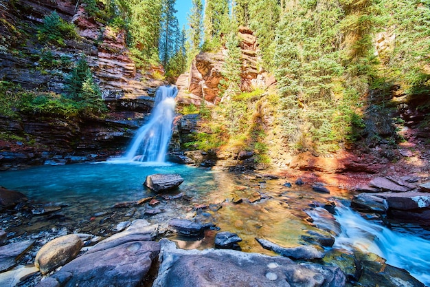 Image of River rocks and canyon with blue vibrant waterfall