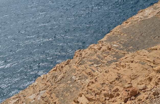 Image of rocky limestone formation in the middle and the blue sea in the other half in ajuy, fuerteventura, canary islands, spain