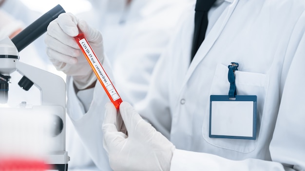 image of a scientist looking at a tube with a test 