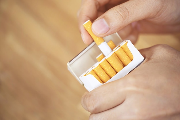 Image of several commercially made cigarettes. pile stack cigarette on wooden. or Non smoking campaign concept, tobacco