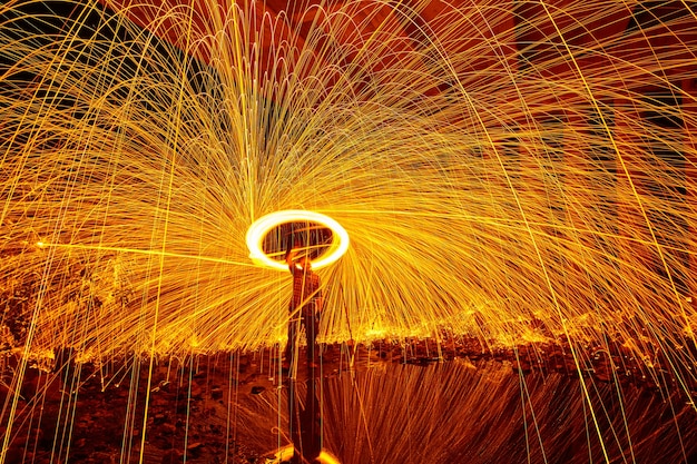 Image of Shower of orange and yellow sparks with a lasso of light from steel wool