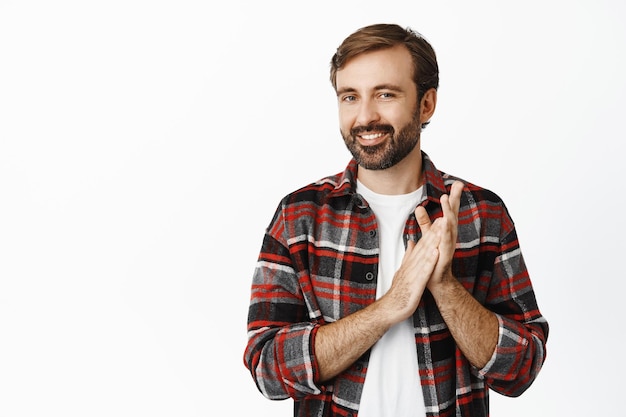 Image of smiling bearded man applausing clap hands and smiling pleased praise something good standing over white background