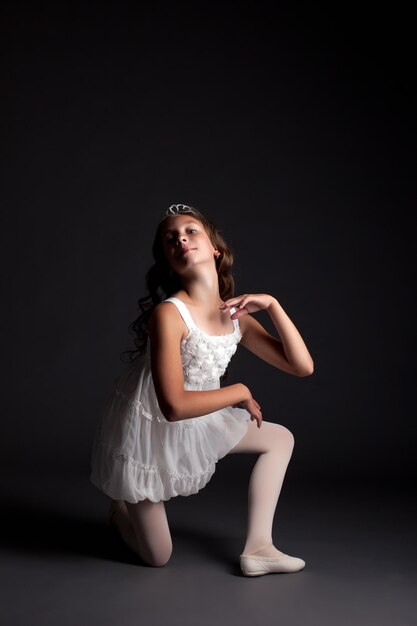 Photo image of smiling young ballerina posing in studio