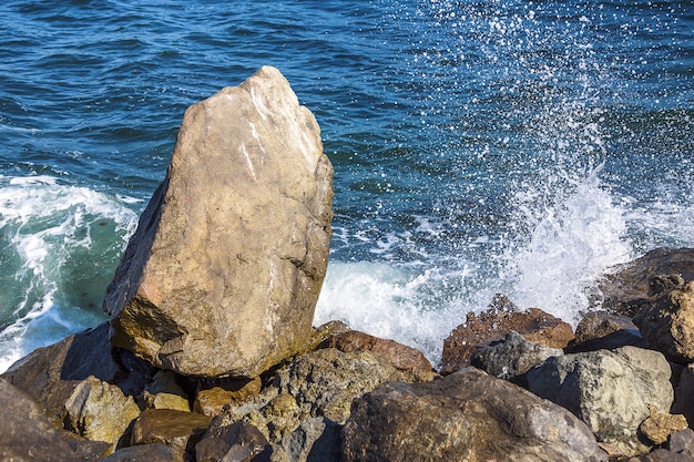 Image of stones in the sea with waves, view from the shore