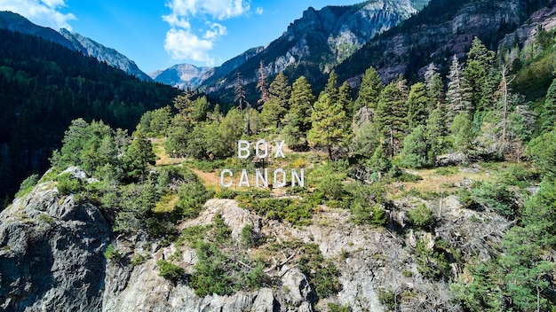 Image of Straight on view of Box Canon sign up in the mountains with valley in background