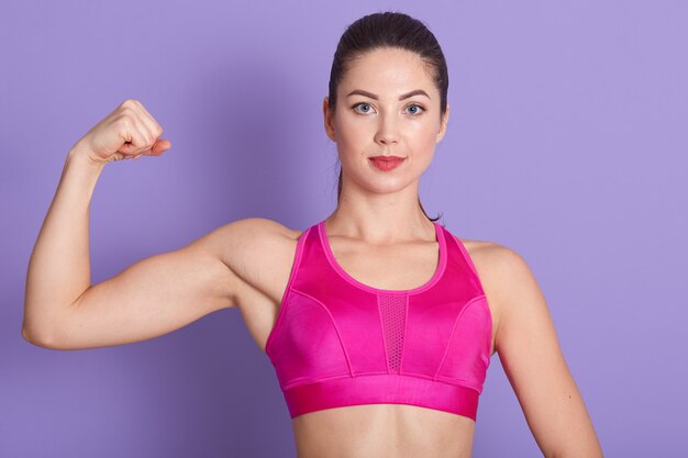 Image of strong confident fitness trainer looking directly at camera