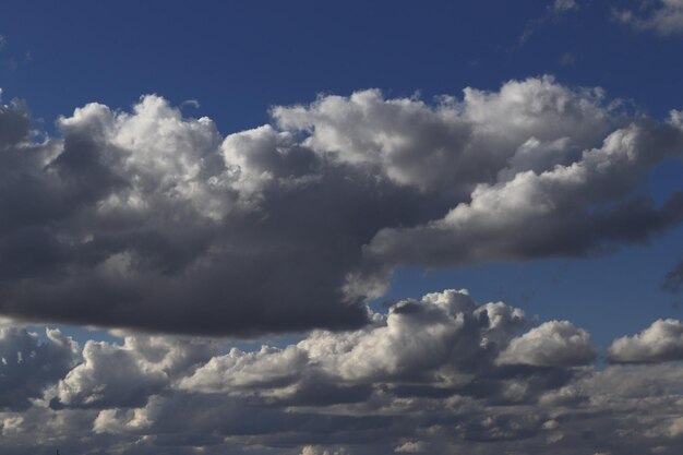 An image of a summer blue sky with a beautiful pattern of white clouds of various shapes