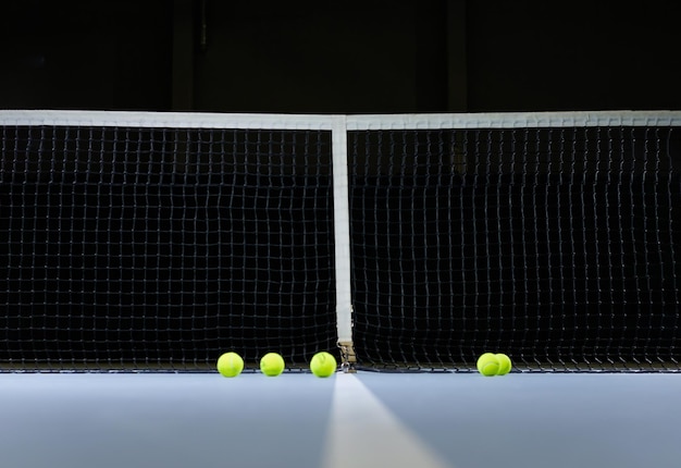 Foto immagine di un campo da tennis rete e palle luce drammatica concetto sportivo