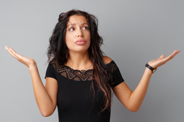 Image of thinking young woman standing