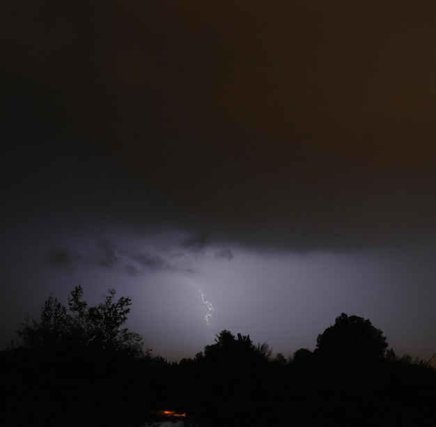 Image of thunder lightning against grey stormy sky with copy space