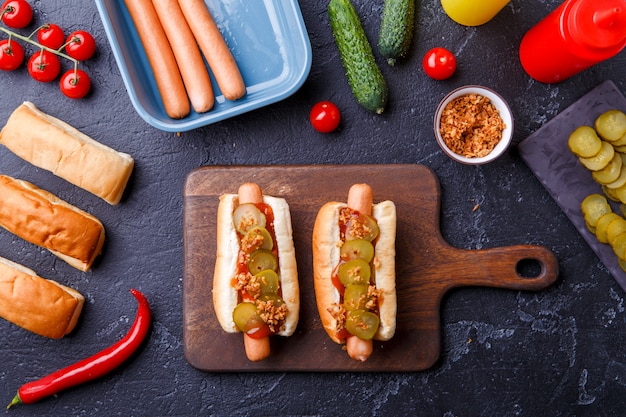 Image on top of two hotdogs on cutting board on table