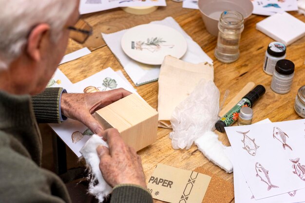 Image transfer workshop Elderly man working the wood to transfer images