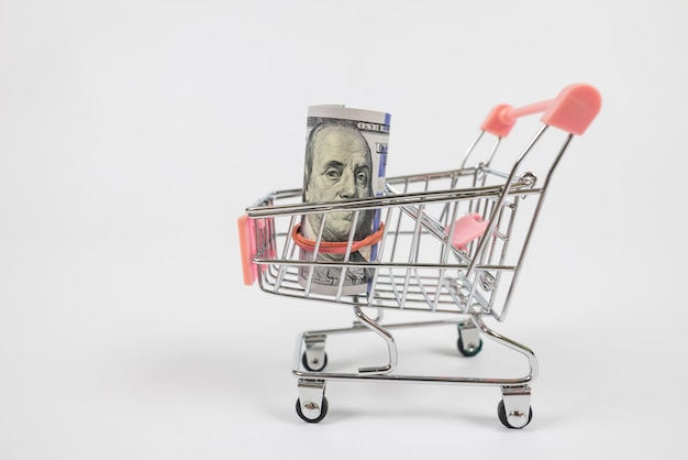 Image of trolley cart with bank note isolated in white background with copy space Economy and market concept