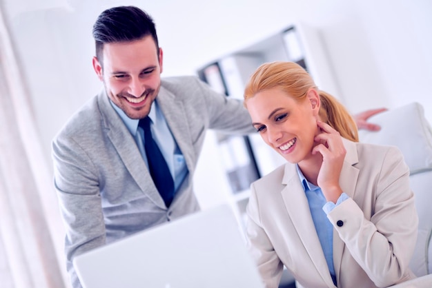 Image of two business people working at meeting in officeThey are in discussion while using a laptopThey have a problem in new project