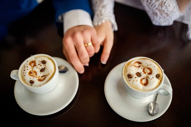 Image of two peoples hands with wedding rings.