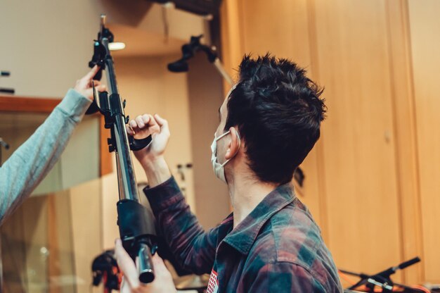 Image of an unrecognizable man setting up a microphone in a music recording room