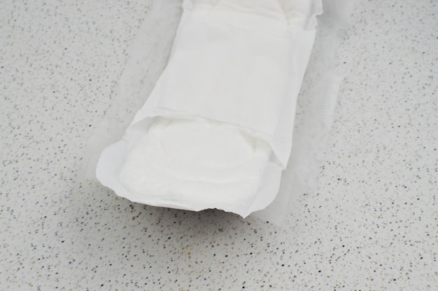 Image of an unused white sanitary pad strategically placed on a table representing female wellbeing