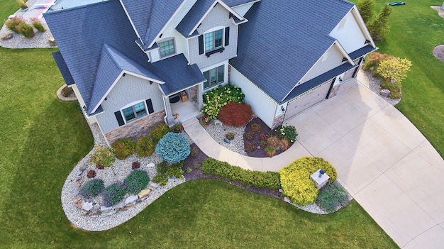 Photo image of view of outside of traditional american house with beautiful summer landscaping