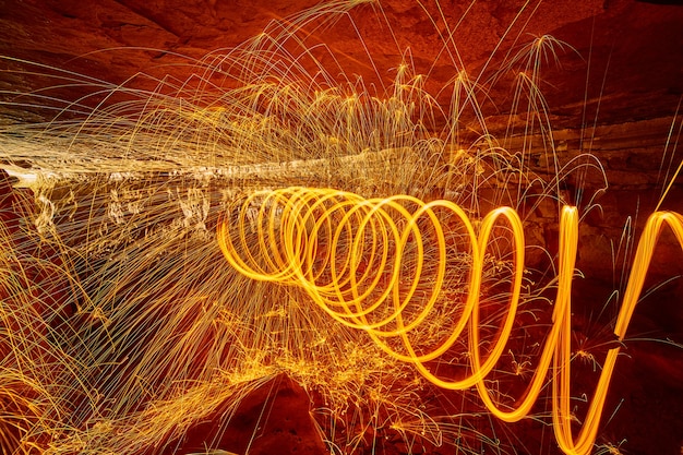 Image of Wall of fire and sparks inside a cave with a spiral swirl of yellow and orange