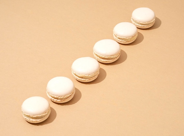 Photo an image of white macaroons on a tan background with plenty of copy space for text or logo overlay