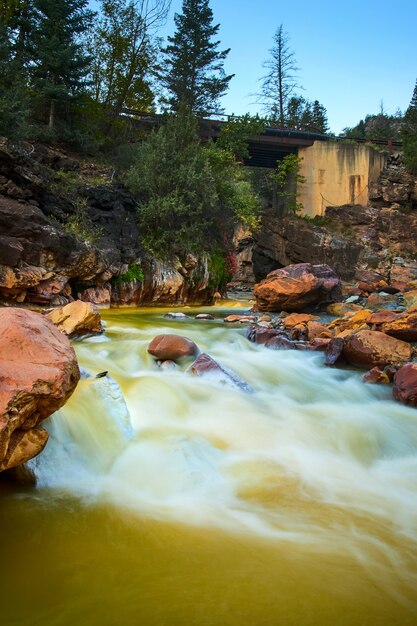 Foto immagine di rocce bianche nel fiume di acqua minerale con ponte e scogliere sullo sfondo