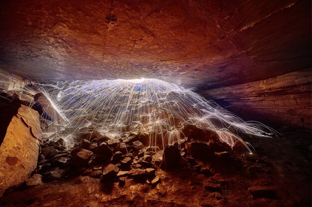 Photo image of white steel wool sparks illuminating cave exit