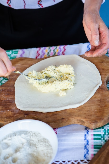 image with the hands of a lady cooking traditional Romanian fried pies with cheese