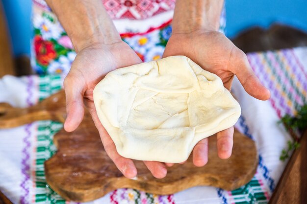 image with the hands of a lady cooking traditional Romanian fried pies with cheese