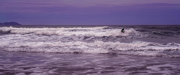 Изображение с серфером в море на закате