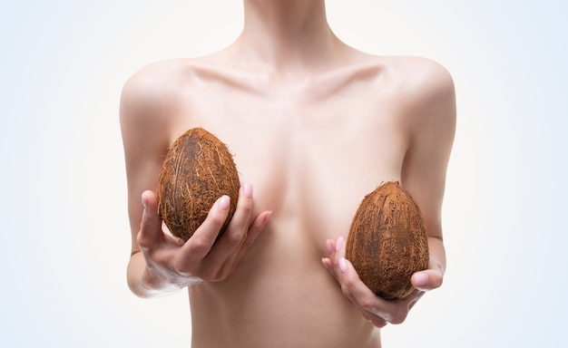 코코넛으로 덮인 여성의 가슴 이미지. 성형 수술 개념. 포유류 학. 실리콘 임플란트. 혼합 매체
