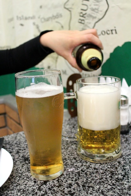 Image of woman' s hand pouring beer in a glass