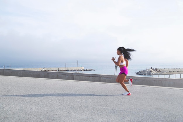 Image of a woman in sportswear jogging in the port mixed race outdoor runner active lifestyle