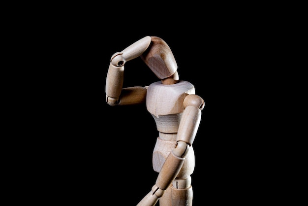 Image of wooden manikin on black background poses different posing