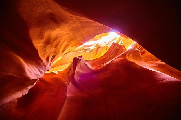 Image of worm\'s eye view from the bottom of an orange canyon\
looking up towards the sunlight