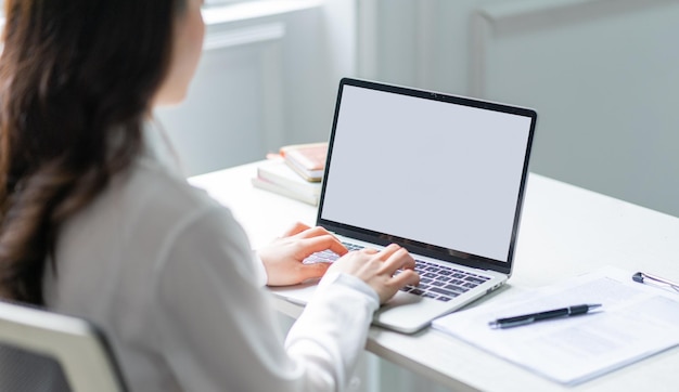 Photo image of young asian business woman using laptop with blank screen