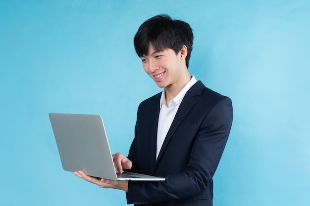 Image of young Asian businessman wearing a suit on a blue background