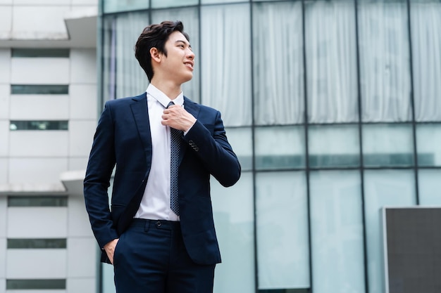 Image of Young asian businessman with glass building background