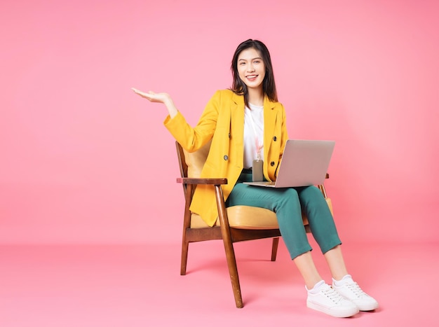 Image of young Asian businesswoman sitting on chair