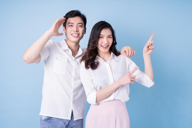 Image of young asian couple posing on blue background