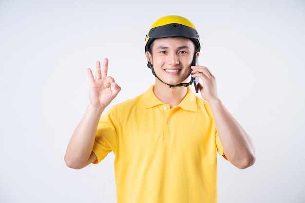 Image of young Asian delivery man on background