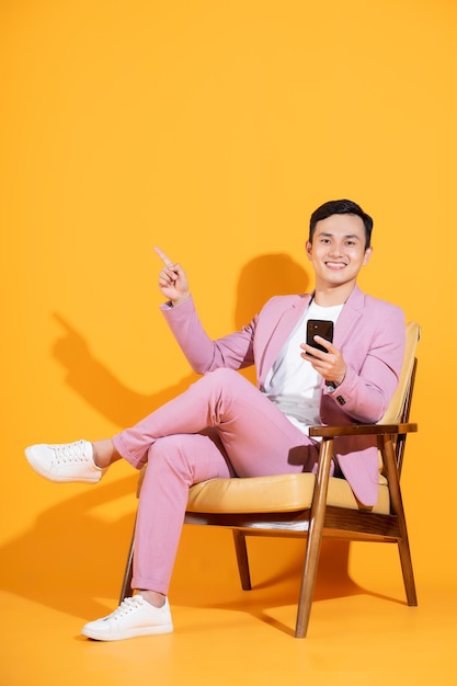 Image of young asian man sitting on chair