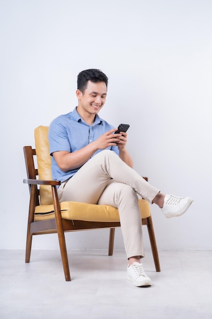 Image of young Asian man sitting on chair