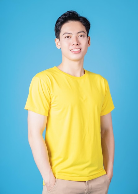 Image of young Asian man with yellow tshirt on background