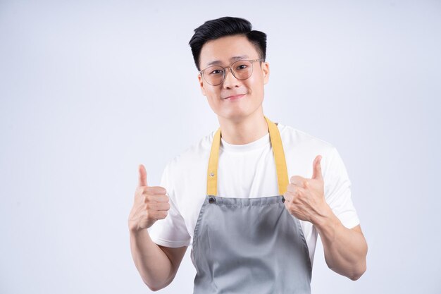 Image of young Asian waiter on background