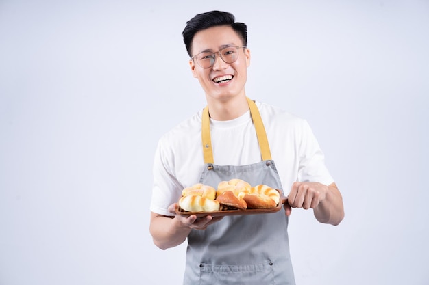 Image of young Asian waiter on background