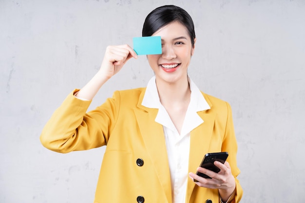 Image of young asian woman holding bank card